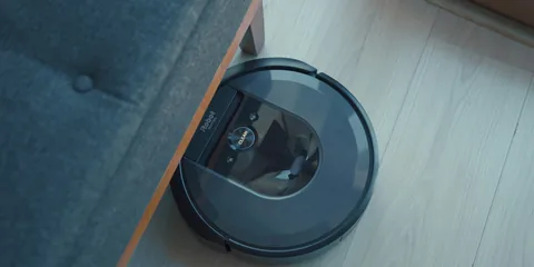 Robot vacuum cleaning next to a sofa