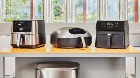 Three air fryers side by side on a kitchen counter