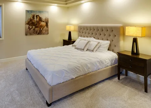 Bed with a white mattress in a bright bedroom